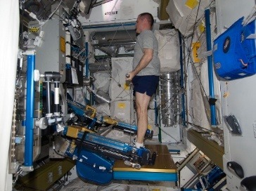 Astronaut using an exercise loading device aboard the ISS