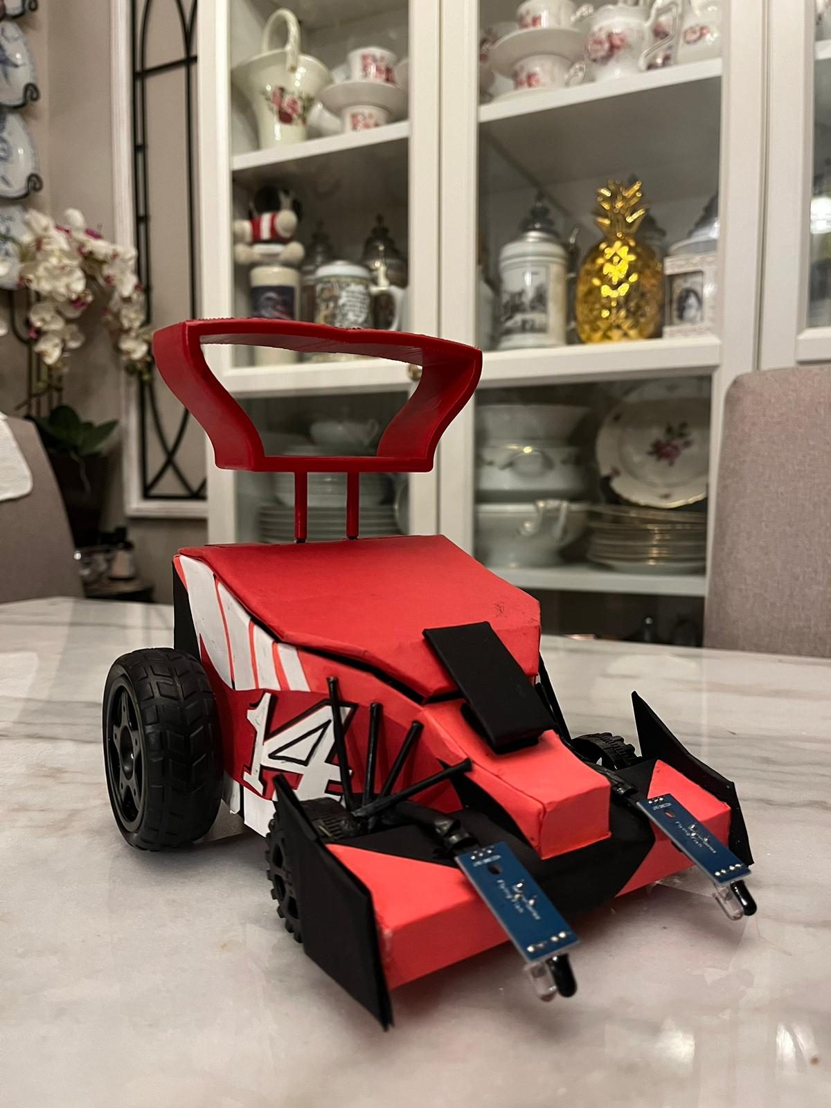 Red and black robot car prototype with sensor whiskers